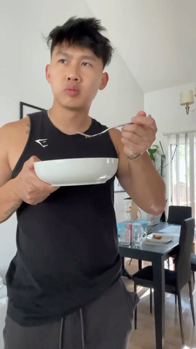 man eating from bowl while standing up